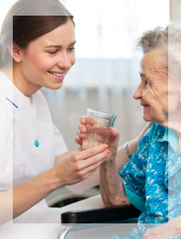 caretaker giving a glass of water to her patient